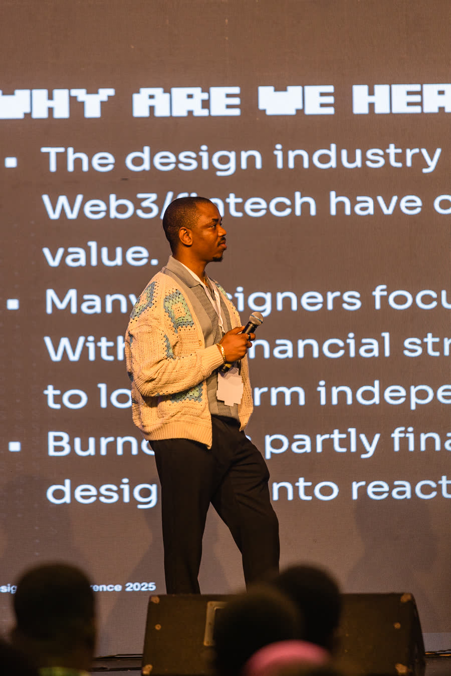 Druids on stage at a design conference, presenting a slide titled Why are we here